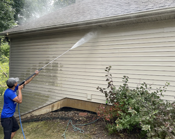 Hydro Professional Exterior Cleaning technician pressure washing vinyl siding in Fort Wayne, IN